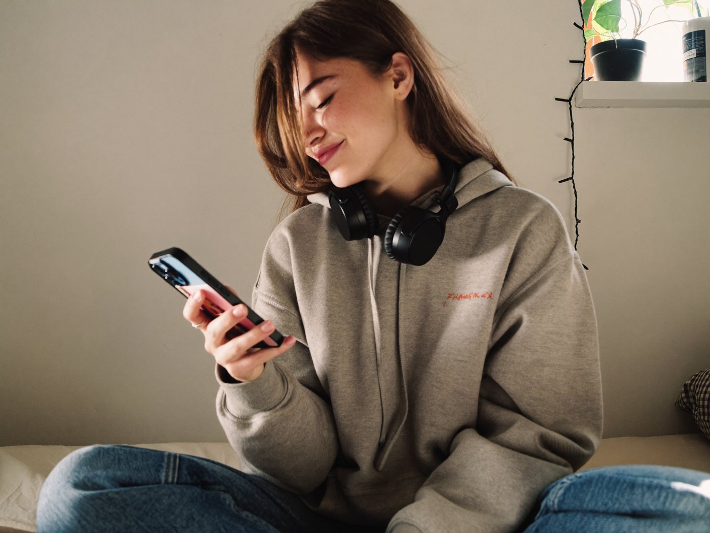 A teenager on her bed looking at her phone
